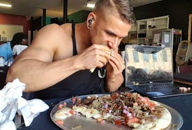 Joel Hansen, a former Wellington resident, continues to eat as he reaches the half-way point of tackling a six-pound donair challenge.