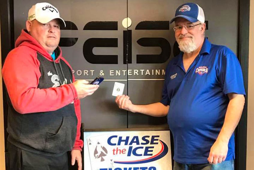 Scott Bridges, (left) manager of Slemon Park Plex, shows how Chase The Ice tickets can be purchased online, including from a phone, while Cecil Gallant, vice-president of the Capitals Booster Club, holds the elusive Ace of Spades which still remains in play.