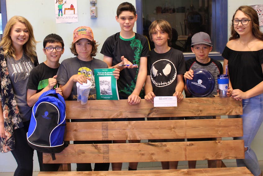 Members of the Hard Workers Youth Services Co-op are holding a lottery to raise funds to cover their administrative costs. They’re offering this park bench they built as the first prize. Showing the other prizes are, from left, co-ordinator Mélanie Arsenault, member-workers: Kayden Arsenault, Tyson Short, Jaden McInnis, Jake Gallant, Jackson Arsenault; and co-ordinator Makenzie Hayes.