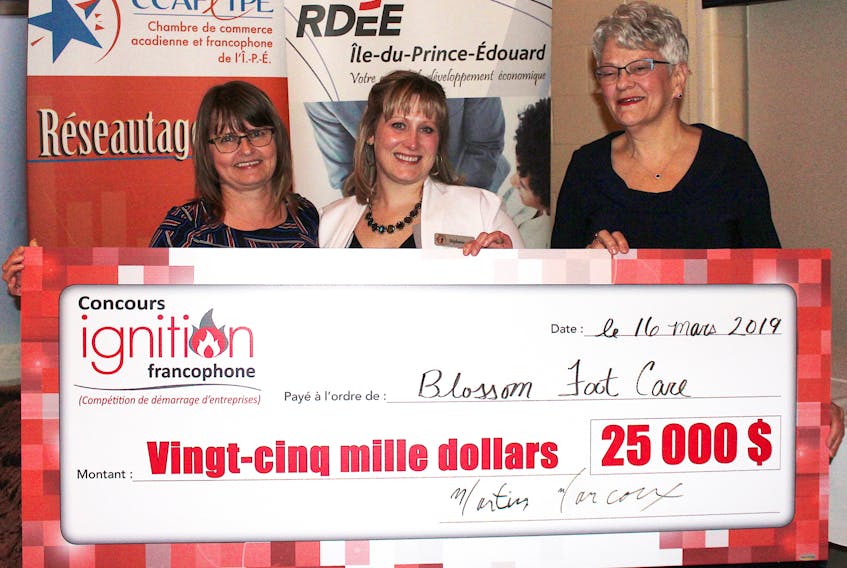 Stéphanie St-Onge, centre, champion of the 2019 Francophone Ignition Contest staged by RDÉE P.E.I. March 16, accepts her $25,000 cheque from contest co-ordinator Velma Robichaud, left and Lt.-Gov. Antoinette Perry.