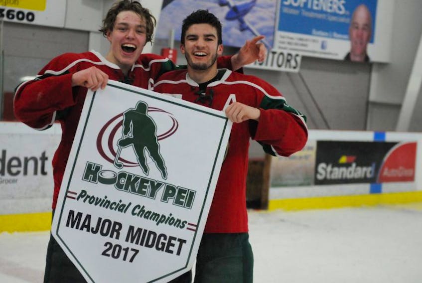 Kensington Monaghan Farms Wild forward Zach Thususka, left, and teammate Evan Gallant hold the provincial major midget hockey championship banner after defeating the Charlottetown Bulk Carriers Pride 6-1 in Game 7 of the best-of-seven series on Saturday night. Thususka was named the series most valuable player.