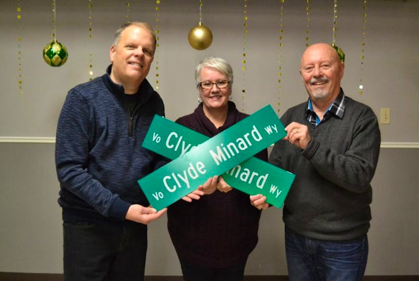 Transportation, Infrastructure and Energy Minister Paula Biggar, presents Andrew, left, and Kenny Minard with their own street signs in memory of their late father. A cul-de-sac in Tyne Valley was officially named in memory of the late community leader Monday.