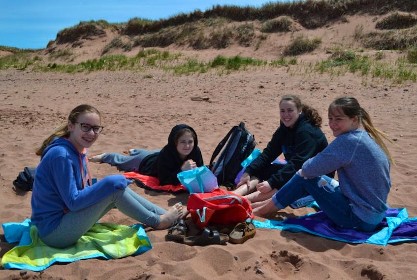 M.E. Callaghan Intermediate School Grade 7 students, from left, Paige Gavin, Reese Arsenault, Macy Hackett and Bryanna Gaudet enjoy some beach time on their lunch break while participating in a beach-dune ecosystem fieldtrip to Miminegash beach on Thursday.