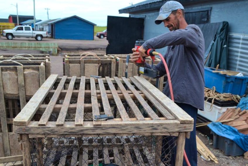 Jason Chaisson makes some final adjustments to lobster traps belonging to his captain, Mark McRae. Fall lobster crews are busy getting ready for their season which opens on Tuesday, August 8.
