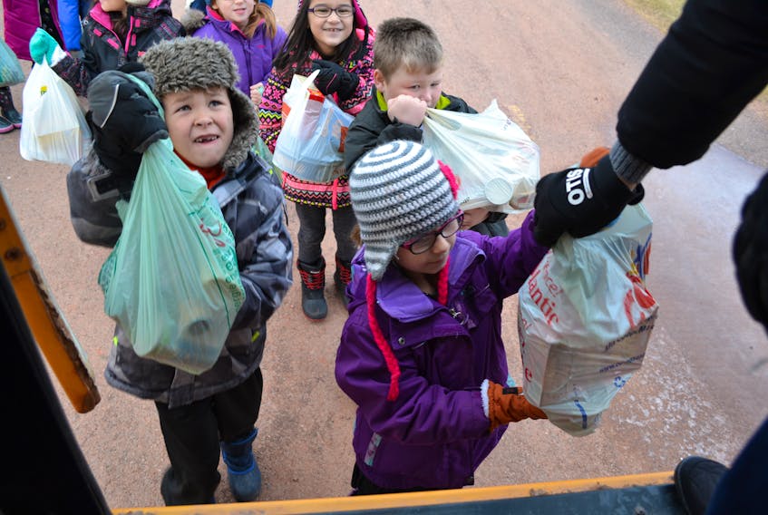 Brooke Gordon hands off a bag of groceries as classmate Ben Gallant prepares to do the same. Next in line with food for the Immaculate Conception Parish Christmas Hampers are fellow St. Louis Elementary students Cole Millman and Savannah Gallant.