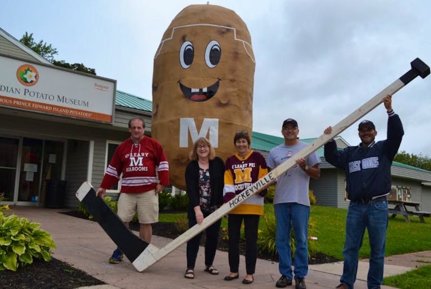 O’Leary Kraft Hockeyville committee members, from left, Bill MacKendrick, Jo-anne Wallace and Della Sweet, along with Glen Sweet and O’Leary Recreation Director Jeff Ellsworth hold up Bud’s giant Hockey stick. Glen and Della Sweet, with help from a Stetson’s Electric boom truck spent much of Sunday afternoon dressing up the  O’Leary Museum’s giant potato as a hockey player for the town’s Hockeyville celebrations.
