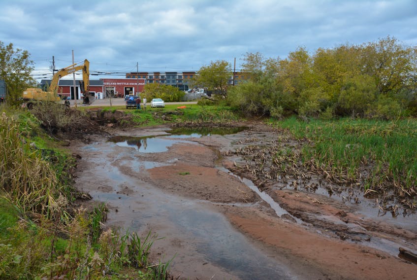 An excavator was brought in Tuesday morning to pull out the old dam at what was once known as the Summerside Ice Pond on South Drive.