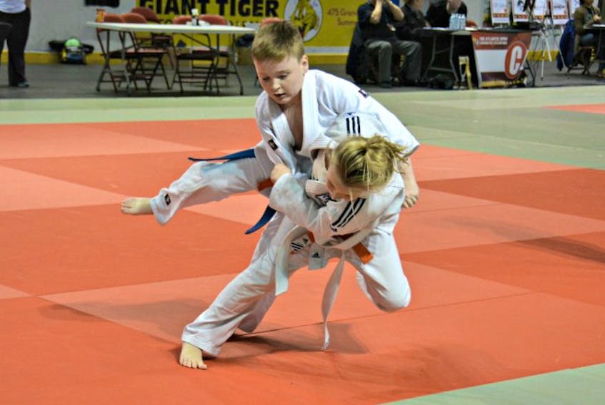 Summerside’s Toshidokan Judo Club member Grace Simmons, 9, attempts to throw opponent Liam Clements, 10, over her shoulder in the Atlantic’s Open Judo Championships u12 category at the Credit Union Place on Sunday. Simmons was awarded gold medal.