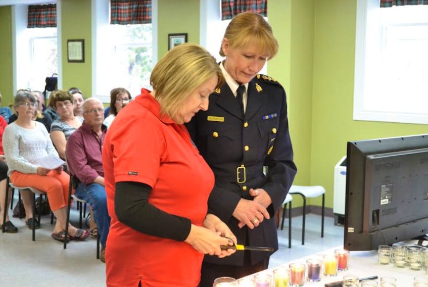 Chief Superintendent Joanne Crampton, the RCMP’s commanding officer for P.E.I. accompanies Trudy Betts as she lights a candle during a MADD Canada ceremony in memory of her daughter, Wendy Betts.