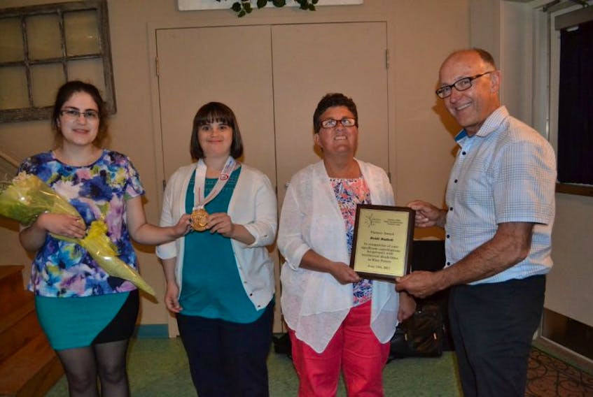 Maurice Poirier, right, chairman of Community Inclusions’ Board of Directors, congratulates the organization’s chairwoman, Heidi Mallett, on being named the 2017 recipient of the Pioneer Award. From left are Laura Sarlo, master of ceremonies for Community Inclusions’ annual meeting and gold medalist Janet Charchuk who spoke about her recent participation at the Special Olympics world games in snowshoeing.