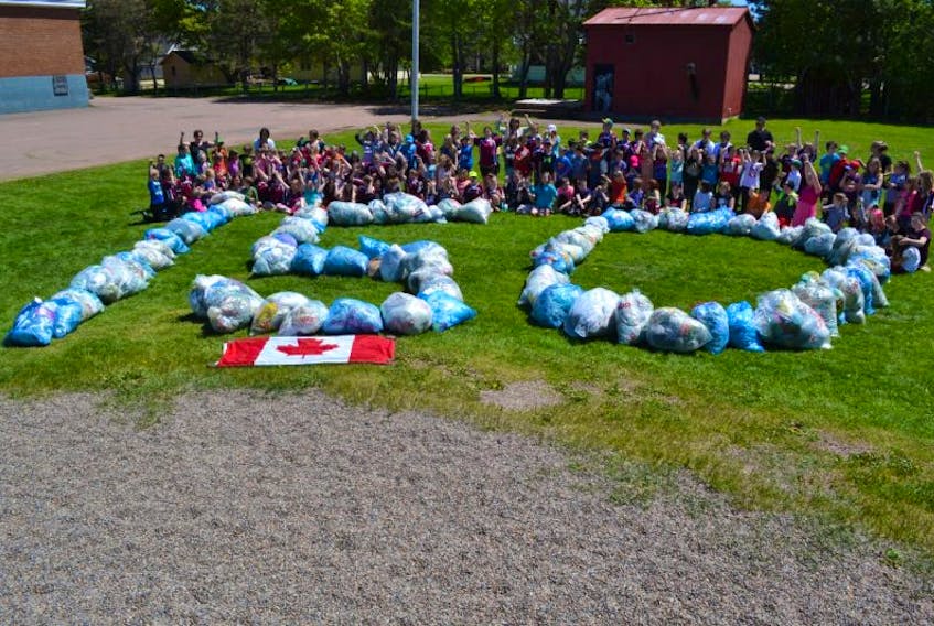 O’Leary Elementary students and staff gather behind a Canada 150 display made from the grocery bags they collected for an environmental challenge.