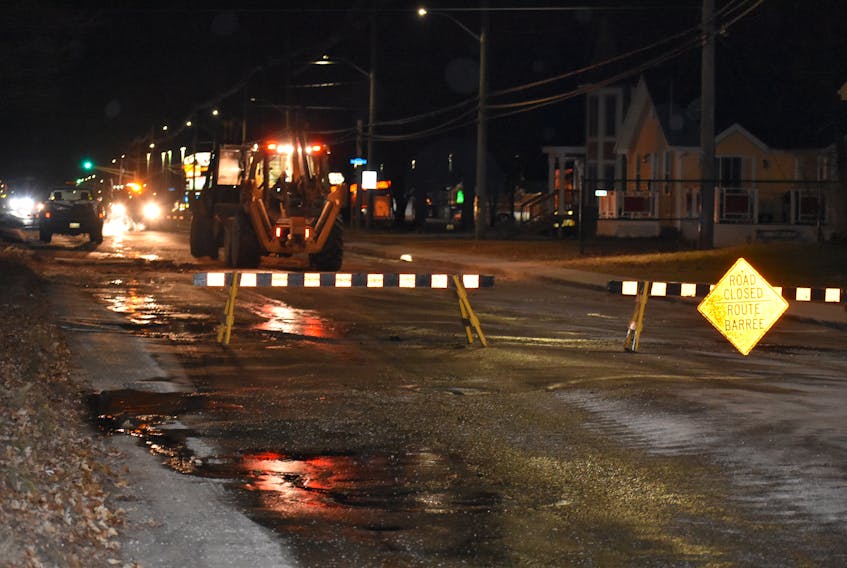 Trucks work hard to clean up Granville Street, near the entrance of Boswell Crescent, after a pipe burst on Sunday.