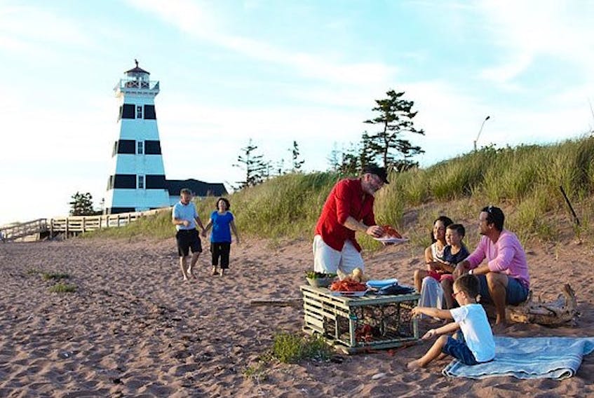 John Martin, in red, owner of P.E.I. Tours and Experiences, cooks up a feed of lobsters for clients right on the beach in West Point. Martin feels the increase in tourism numbers in western P.E.I. will fuel future tourism growth.
