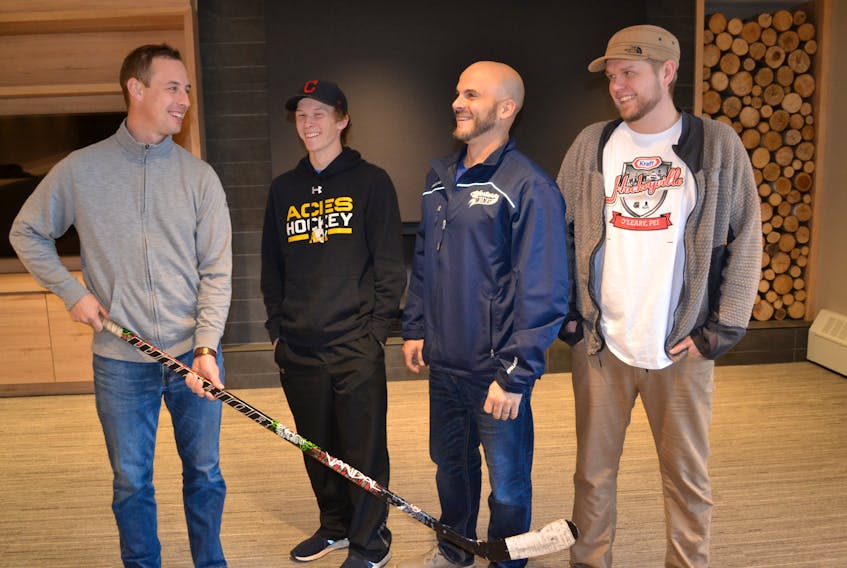 The Mill River Resort Hockey Classic Dec 1 - 3 is attracting 43 teams to western P.E.I. Geoffrey Irving, from left, on behalf of the sponsor, reviews details with Will Tuplin, Jeff Ellsworth and Joey Dumville.