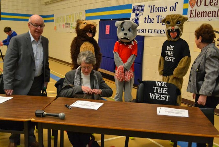 The Board of Directors of the P.E.I. Public Schools Branch, from left, Harvey MacEwen, Susan WIllis and Pat Mella are escorted to their seats for the Westisle Family of Schools public meeting Tuesday by school mascots.