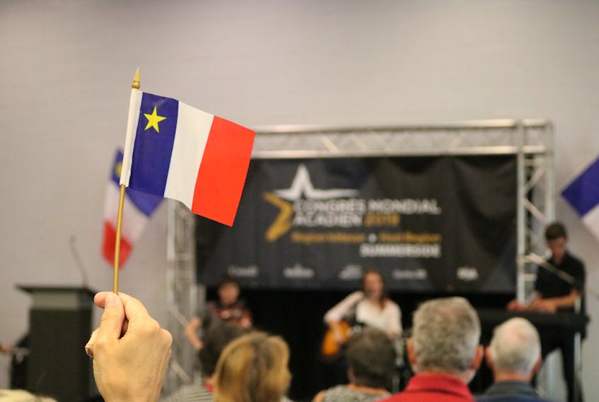 One of about 50 attendees waves an Acadian flag at the recent announcement for the Congrès Mondial Acadien, recently in Summerside.