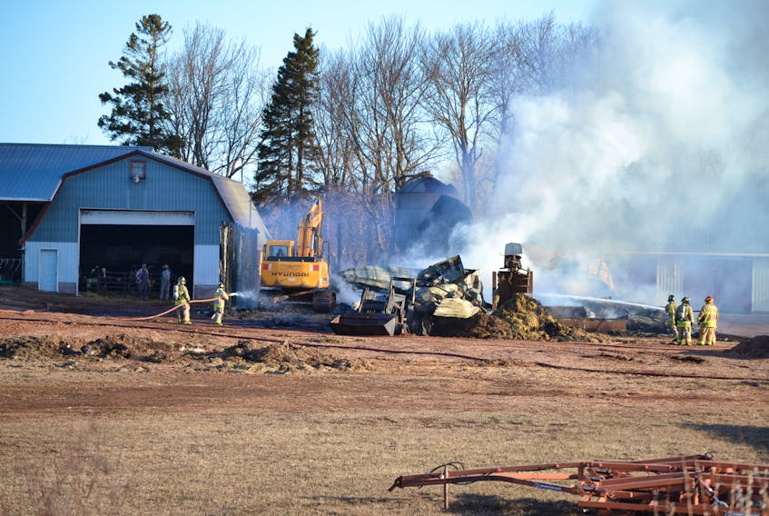 An excavator pokes through the rubble of a milk house which was destroyed by fire early Tuesday in Alma. An estimated 36 cows perished in the fire but cows in an adjacent barn were spared.