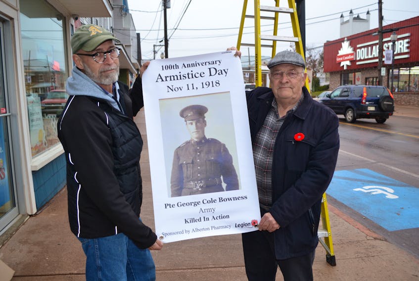 Garth Davey, left, special events coordinator for Alberton, and Alan Curtis, a coordinator of the St. Anthony’s Legion banner project, prepare to suspend one of the legion’s armistice day banners. Each banner features a Bloomfield or Alberton area person who served for Canada during World War 1.