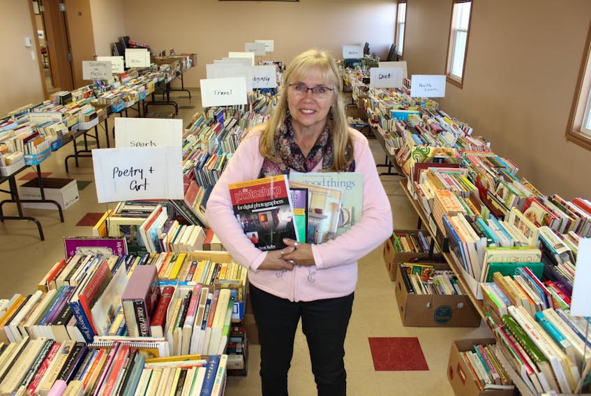 Anna MacDonald, coordinator of the Journal Pioneer/Rotary Book Sale for Literacy, showing off some of the many treasures available for purchase at the sale, which starts Thursday, Sept. 27.