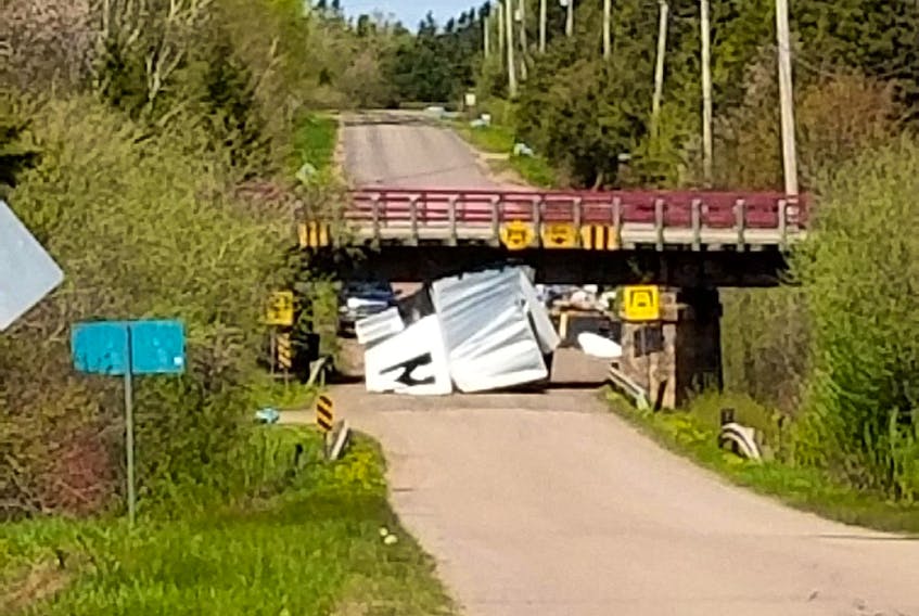 The cargo box remains on the road beneath a Confederation Trail overpass in Tignish on Monday. A driver of a commercial truck failed to notice the signs warning of a nine foot, 10-inch clearance, an RCMP officer reported.  Except for the box, the truck was otherwise undamaged.