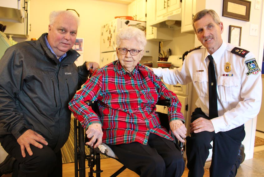 Ruth Waite has been sending a Christmas fruit cake and a chocolate cake to the Summerside Police Service station for the past 34 years to thank Deputy Chief Sinclair Walker, right, and retired Det.-Sgt. Joe Peters, left, for helping to find some of her property that was stolen in 1984.