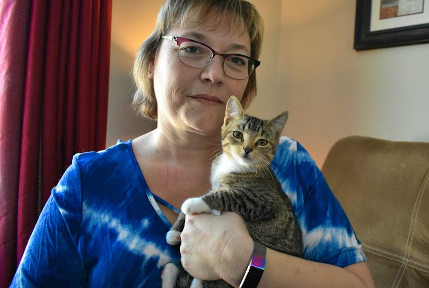 Lori Burnell holds one of the two abandoned feline kittens that were found on the roadside in a red duffel bag.