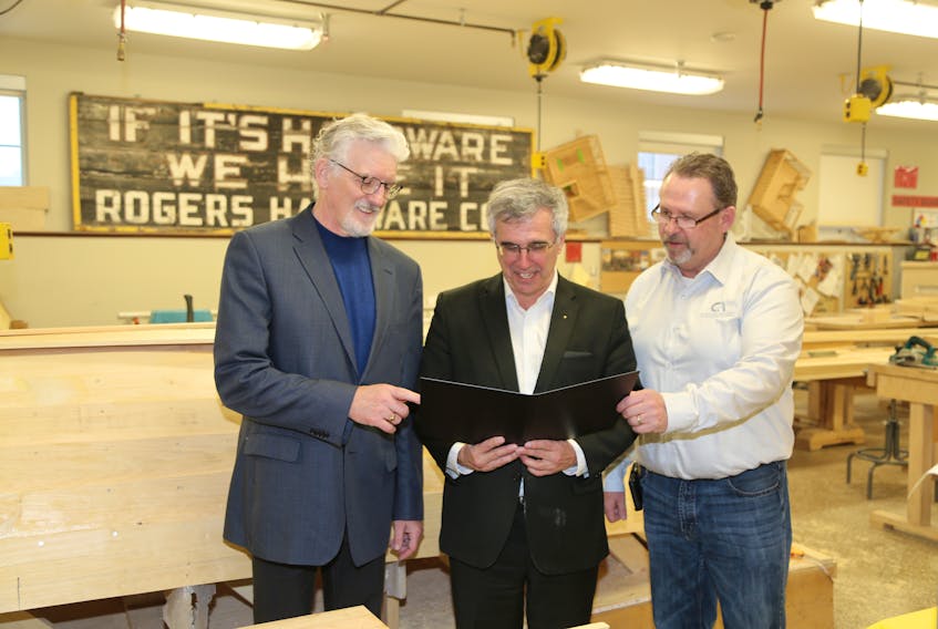 Sandy MacDonald, Holland College's vice president of academics and applied research, from left, looks over material for the new National Building Code course with Richard Brown, minister of Communities, Land and Environment, and Sam Sanderson, executive director for the Construction Industry Association of P.E.I.