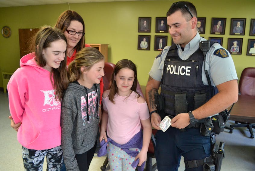 Cst. J-P Cote shows Suzanne Getson and children, from left, Ella Gavin, Amiyah Getson and Mary Jane Gavin Shea the Narcan kit containing naloxone that officers carry in case they are exposed to the drug, fentanyl. During an information session on how to talk to children about drugs, Cote said only a small amount of fentanyl, equivalent to a few grains of sand, can be lethal.