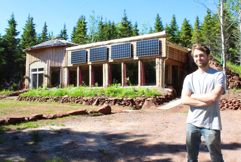 Jayden Charlton stands outside his newly completed Earthship home in Hope River. Charlton has been working on the structure, which used mostly recycled materials in its construction, more than two years ago.