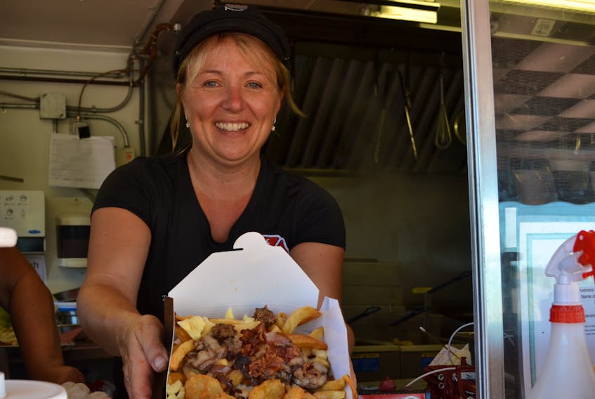 Kelly Wilson serves up the day’s special from her fry truck, Up West Fire Fries.