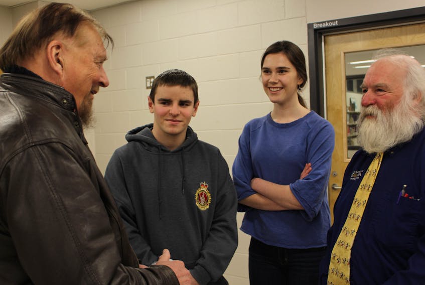 Gwynne Dyer, left, chats with Dylan Corbett, Haley Brennan and TOSH Political Studies teacher Mike Trainor, after giving a lecture on the world in the Trump era and what the future could look like.