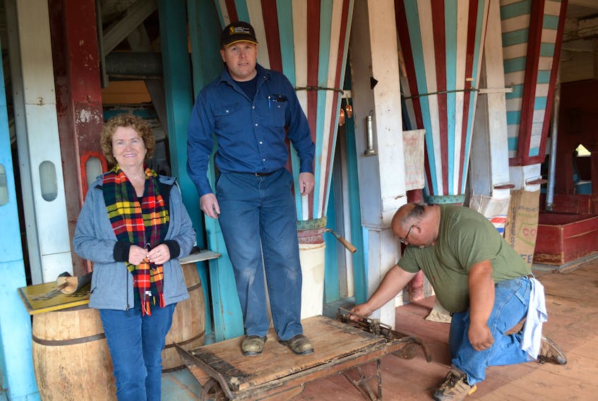 Leard’s Mill Restoration Committee member Justin Rogers puts the mill’s manual platform scales to the test. Fellow committee member Susan Dalton looks on as project foreman Jason Greenan moves the counterweights.