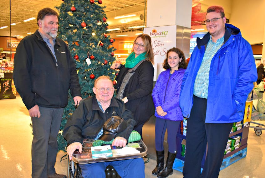 Barrie Gavin, from left, Ernie Gallant, Brenda Gavin, Quinn and Deklan light up the first light on the Christmas tree in memory of their loved one, Judy Gallant.