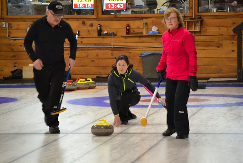 Sweepers Ian MacMillan and Iva Griffin prepare to sweep a rock released by Bobbi-Jean Boylan, mate on the Glen Betts rink, in the P.E.I. Provincial Mixed Curling Championship underway at Western Community Curling Club.