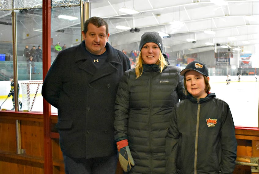 Derek Folland, the Minor Hockey president, from the left, Crystal Cormier and her nine-year-old son, Oliver.
