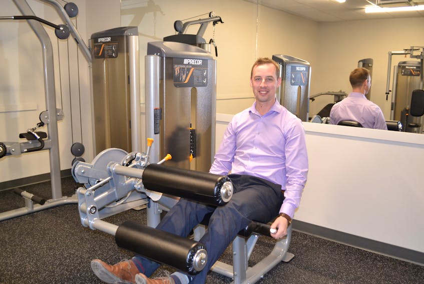 Geoffrey Irving, marketing and events coordinator for the Mill River Resort demonstrates equipment in the resort's new fitness facility. The fitness facility, conference centre, pro shop and sports lounge on the resort's lower level have all been completed and the new restaurant, bar and front entrance will open next week.