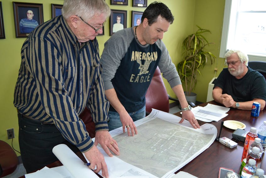 O'Leary town councillor Marvin MacDonald, left, and Mayor Eric Gavin, right, look on as development chair Blake Adams outlines a new residential sub-division plan for town-owned land.