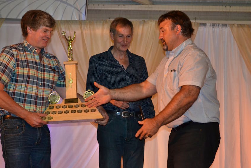 Winston Callaghan, from left, and Harris Callaghan are congratulated by Darryl Wallace, vice-chair of the P.E.I. Potato Board after Callaghan Farms Inc. was declared P.E.I. Potato Blossom Festival’s Potato Producer of the Year.