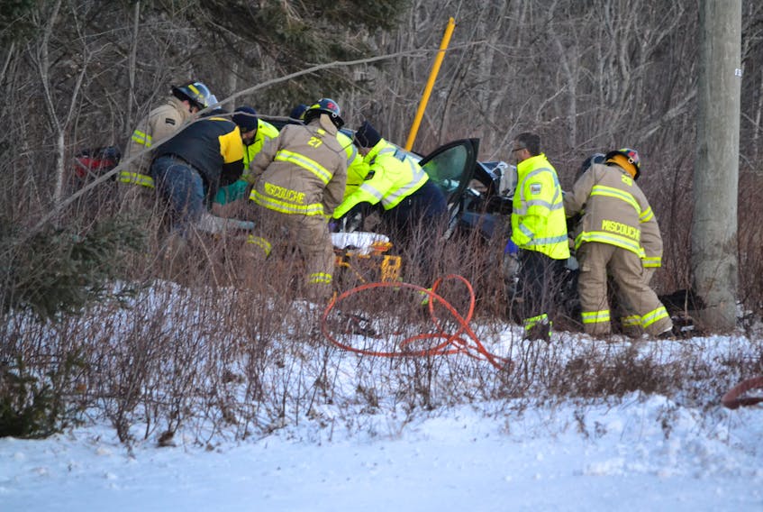 Miscouche firefighters and Island EMS paramedics team up to free a woman from a car following a collision with a Maritime Electric transmission line pole around 4:30 p.m. Monday in Miscouche.