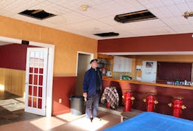 Summerside Fire Chief Jim Peters looks into a hole in the downtown fire station’s ceiling caused by recent water leakage.
