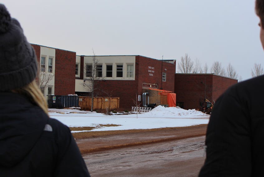 Two students stand outside Three Oaks Senior High School.