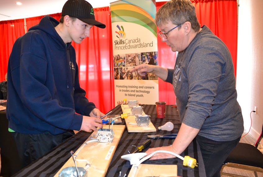 Joel Matthews looks for guidance from red seal electrician and Skills Canada youth outreach coordinator Rosemary Crane during a try-a-trade demonstration at the Western P.E.I. Job Fair.
