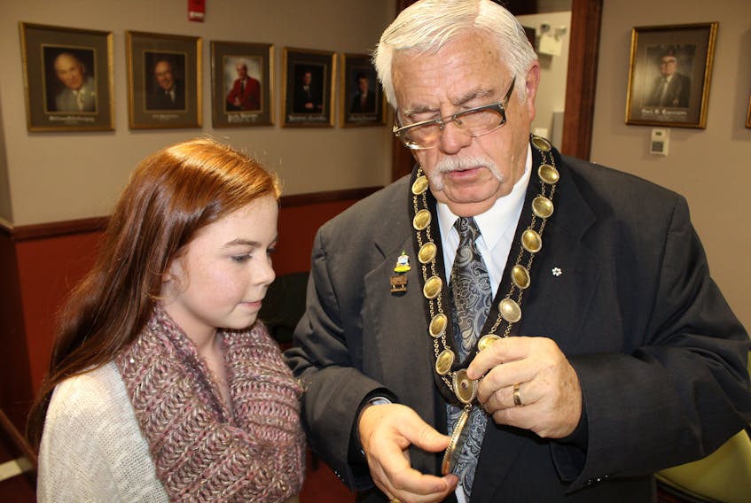 Mya Stewart listens to grandfather Mayor Basil Stewart explain the significance of the Chain of Office.