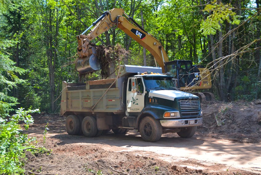 A Curran and Briggs excavator removes brush from the Town of O’Leary-owned Pate property. The town is turning the property into an 18-lot subdivision.