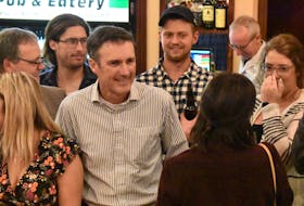 Jamie Fox catches his wife Debbie’s eye as he organizes a group photo at O’Shea’s Pub in Kinkora Tuesday night.