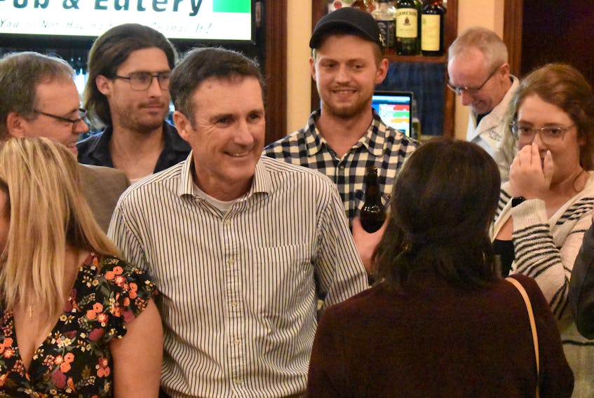 Jamie Fox catches his wife Debbie’s eye as he organizes a group photo at O’Shea’s Pub in Kinkora Tuesday night.