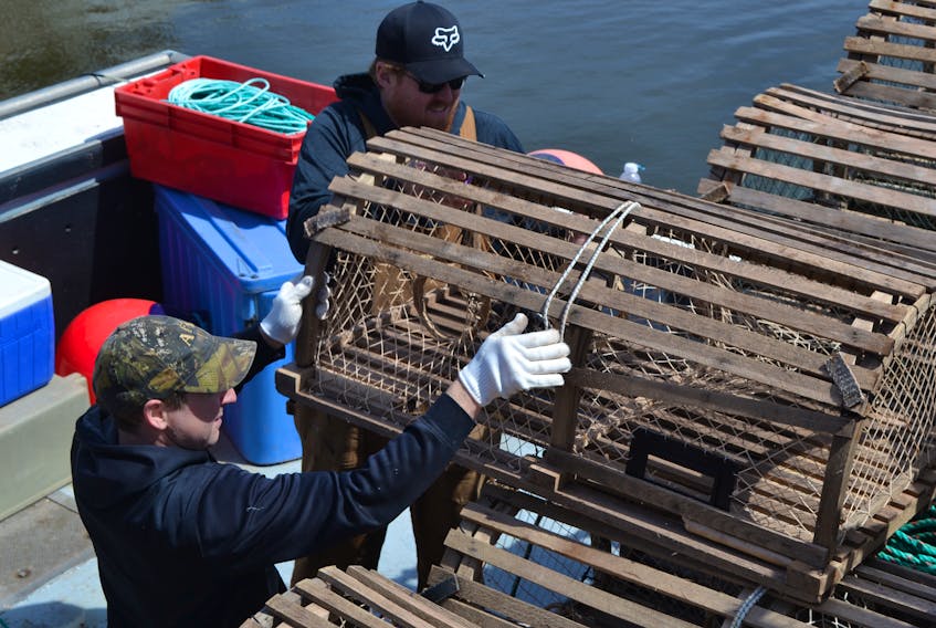 Glen Gallant, left, and Sonny Tremblay pile lobster traps into Gallant’s boat at the wharf in Northport Wednesday afternoon as fishermen get set for the opening of the spring lobster fishery. The Department of Fisheries and Oceans announced Wednesday morning that the spring lobster season, delayed four times because of strong winds in the forecast, would start Friday morning.