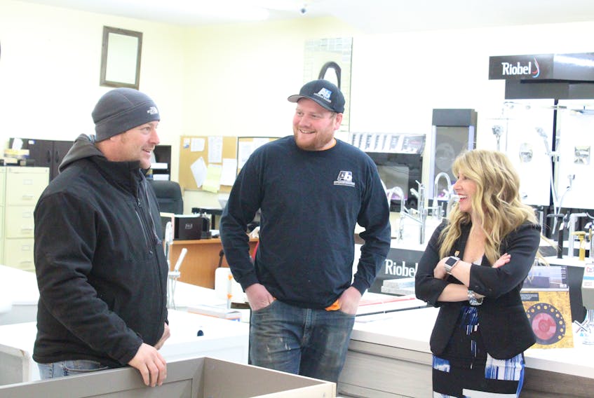 Stefan Corkum, left, of Duffy Construction, and Matt Kingyens, centre, of Advanced builders, chat with Human Services Minister Tina Mundy following an announcement at Callbecks Home Hardware in Summerside Wednesday.