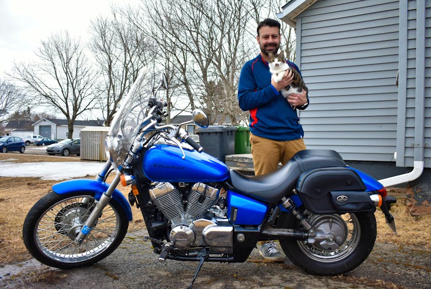 Kindness came full circle for Justin Doiron, pictured holding his cat Fenway, when he posted an ad online looking for a jalopy motorcycle. Never – in his wildest dreams – did he imagine to be gifted a pure pleasure of a ride.