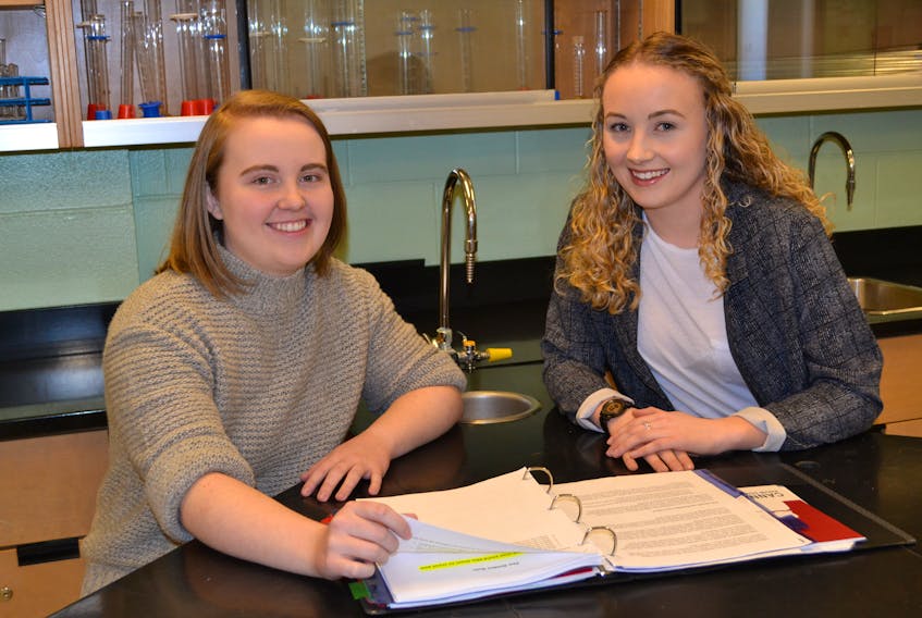 Westisle Composite High School students Olivia Batten, left, and Ashton Grigg compare class notes. Batten was recently awarded a Chancellors Scholarship for Queen’s University, valued at $36,000 and Grigg was awarded an $80,000 Schulich Leader Scholarship.